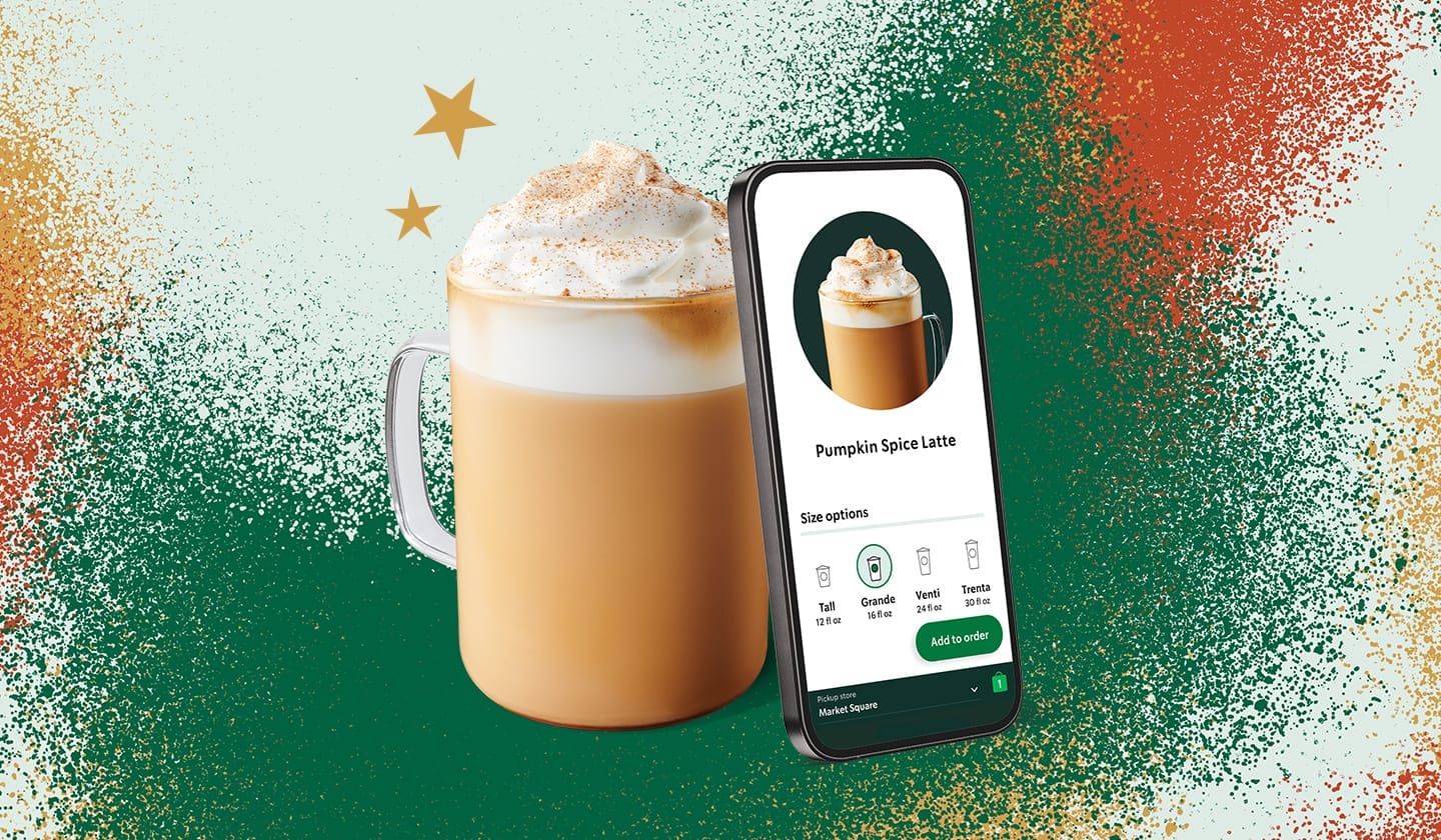 A phone with the Starbucks App open, next to a Starbuck coffee.